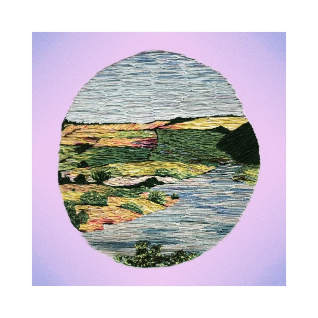 patchwork embroidery of a landscape in blues and greens